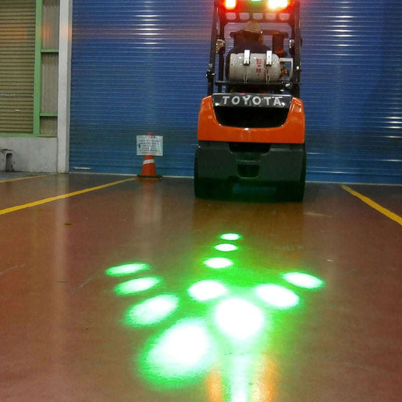 Warehouse worker near forklift with flashing LED safety light